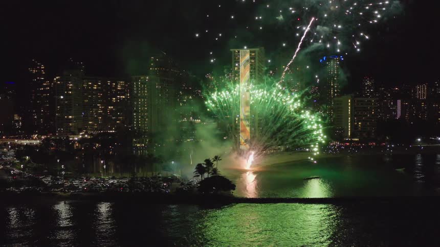 Fireworks explode into colorful sparks in a celebration near the river
