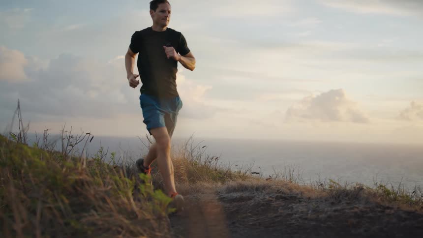 A man runs on a path next to the water