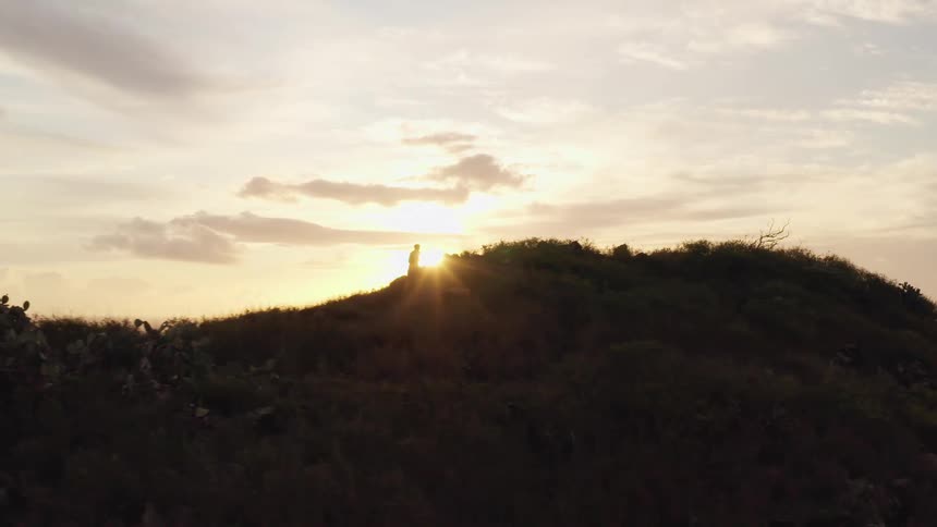 A man is jogging outdoors along the hills