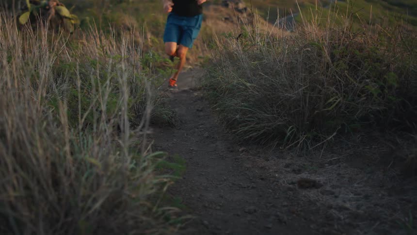 A man runs down a path at sunrise