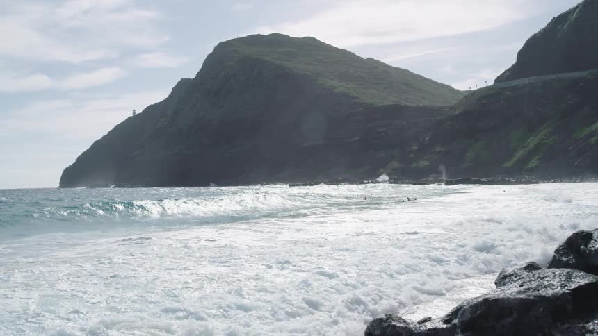 Ocean waves crash against the seashore on a sunny day