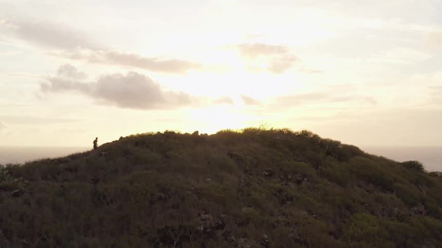 A man jogging up a hill bordering the ocean