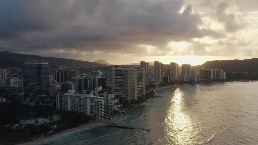 The waves slowly move towards the city on the shore