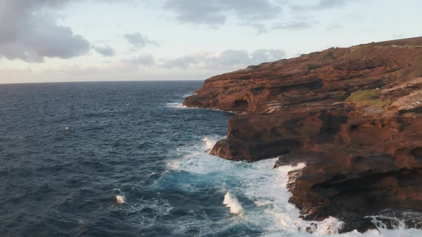 Aerial view of ocean waves crashing against the rocks