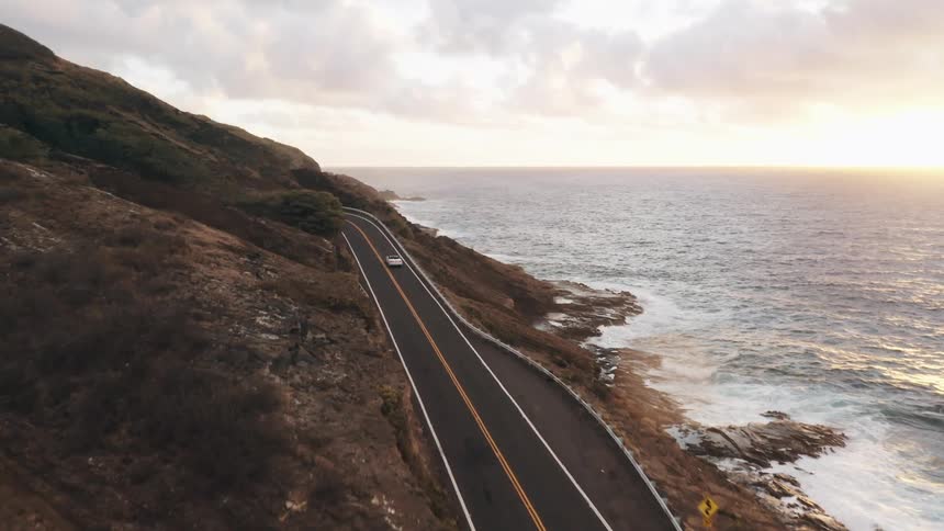 Cars driving along a road next to the water