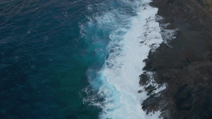 Waves from the ocean are moving towards the rocks