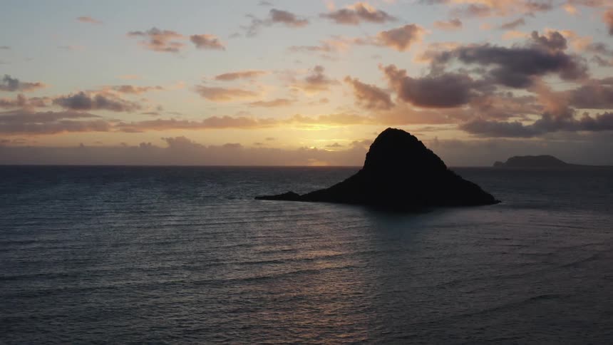 The sun sets in the distance over the vast ocean