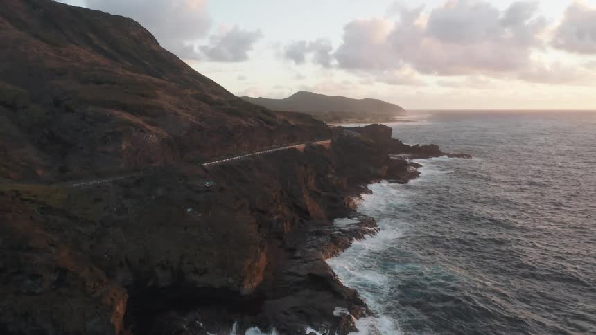 Cars driving down a street along the coastline