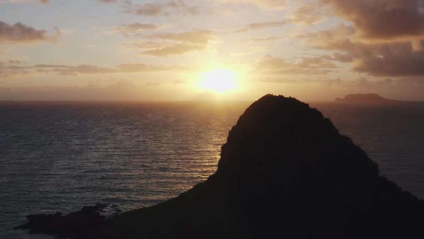 The sun sets on the horizon over the ocean shimmering on the surface