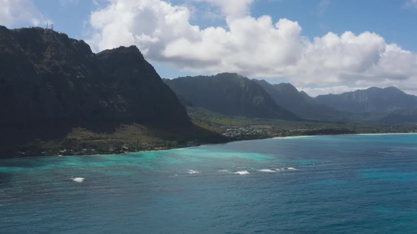 Tropical coastal town near mountains in front of ocean