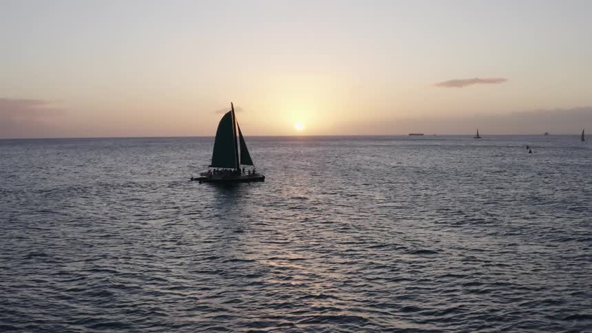 Sailboat on calm sea at sunset