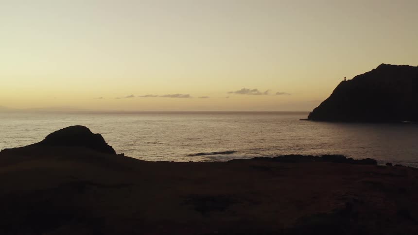 Silhouette of cliff and rocky coast at sunset