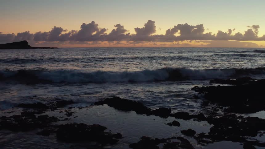 Ocean waves roll over the rocks towards the shore