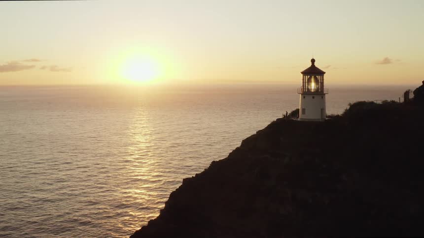 A lighthouse on a hill overlooking the water