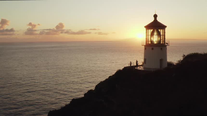 A lighthouse on the rocky shore with the sky in the background