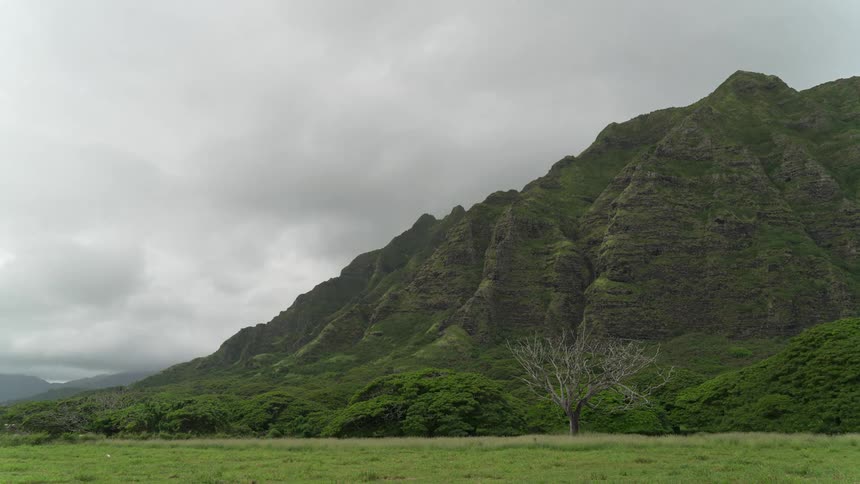 Clouds passing over a mountain covered in vegetation