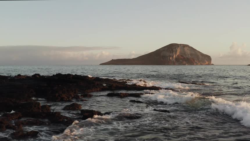 Ocean waves breaks and splash against the rocky shore