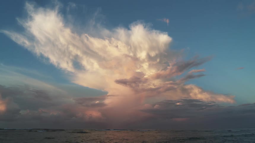Clouds are moving in the sky above the ocean