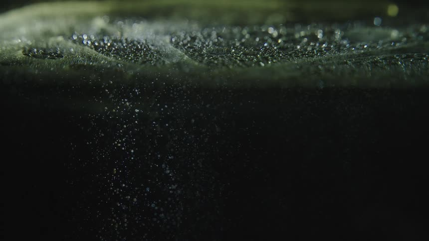 Tiny bubbles rise to top of liquid