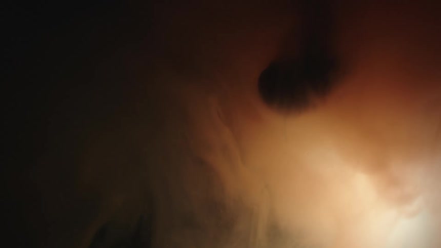 The sun shines behind smoke as it spreads and dissipates