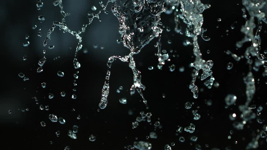 Close up of rain drops falling in slow motion at night