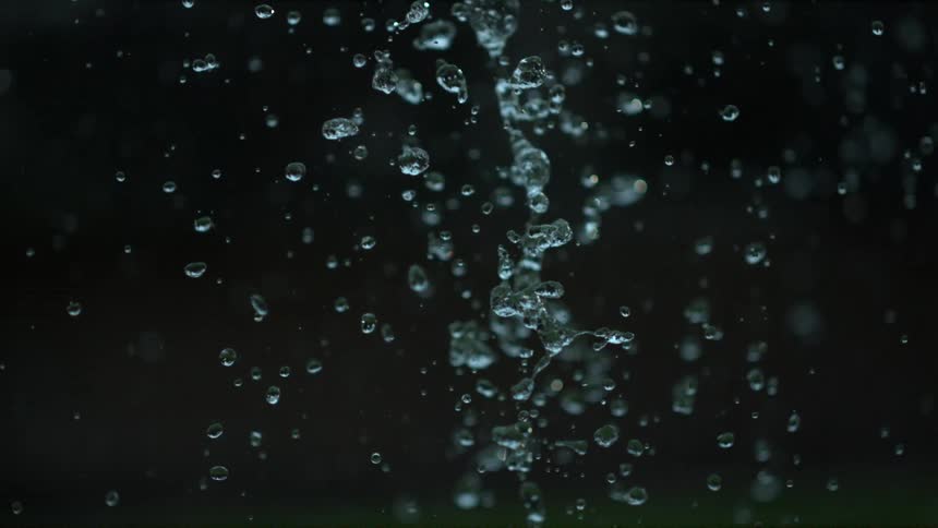 Water drops falling in slow motion against dark background