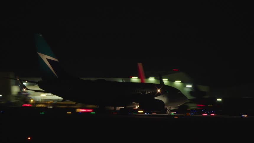 Airplane traveling down runway at night