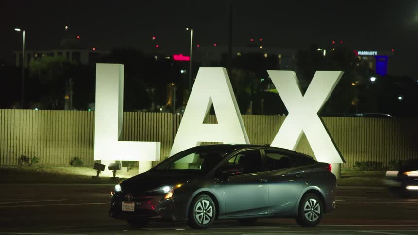 A car is stopped in front of the lax sign