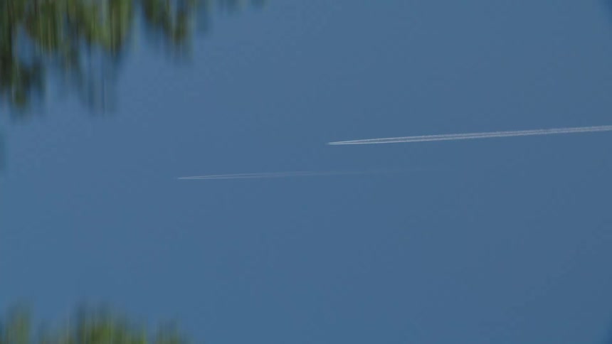 The plane flies through the sky above