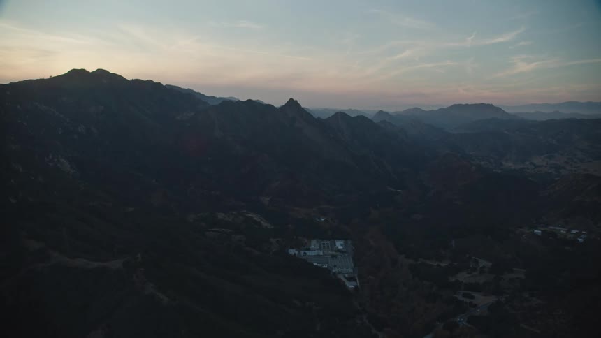 Buildings nestled at the bottom of a mountain range