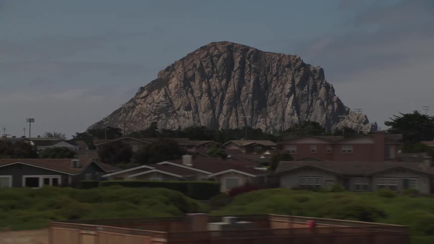A rocky mountain stands in the distance near houses