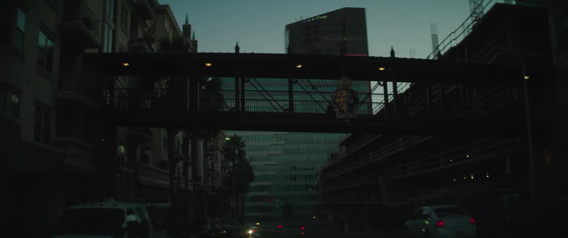 A pedestrian walkway stretches over a city street connecting buildings