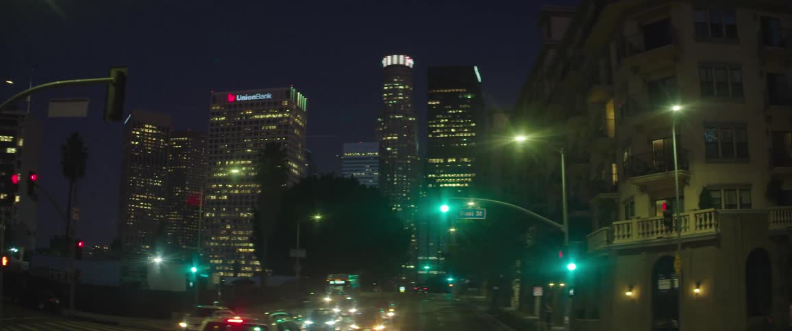 Traffic rides along street toward downtown at night