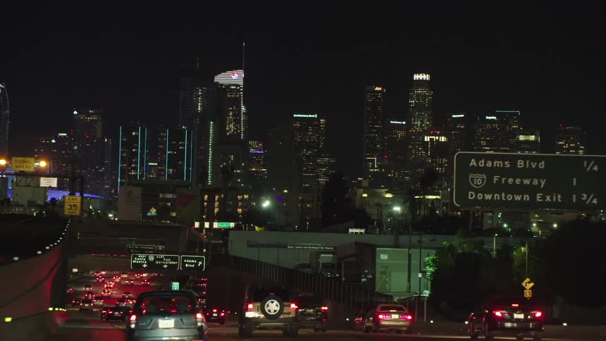 The freeway is packed with traffic near the city at night