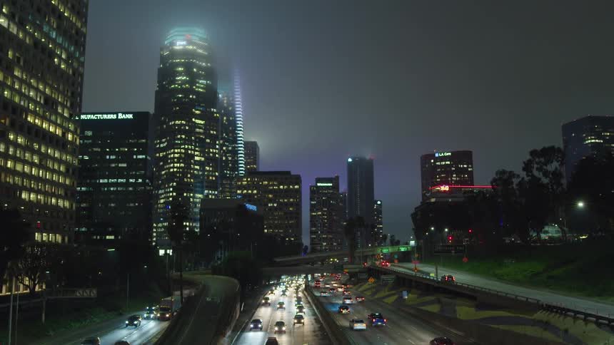 Busy highway passes through downtown covered by high fog