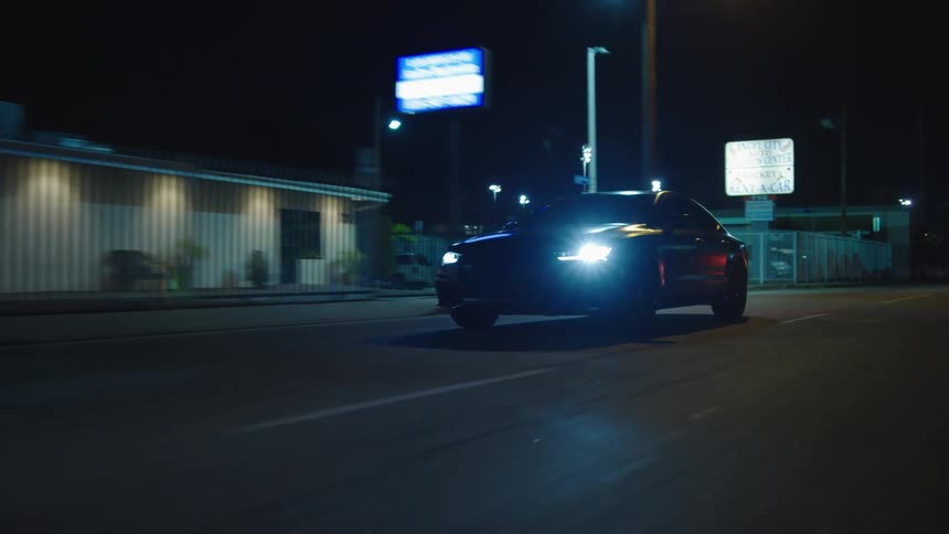 A car driving down a city street at night