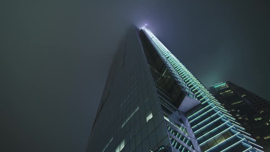 A tall building with lights running up one side of it in a city