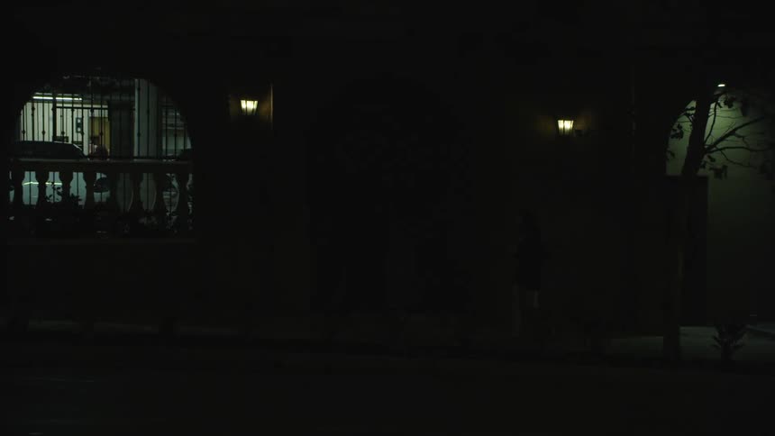 A light pole flickers as vehicles pass by in a city