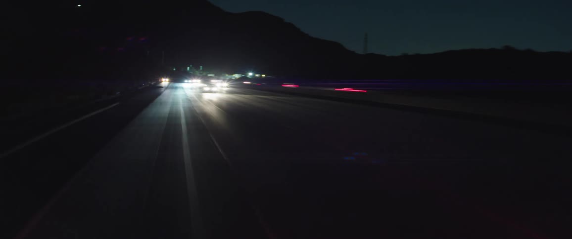 Traffic moves along city freeways passing under bridge and overpasses at night
