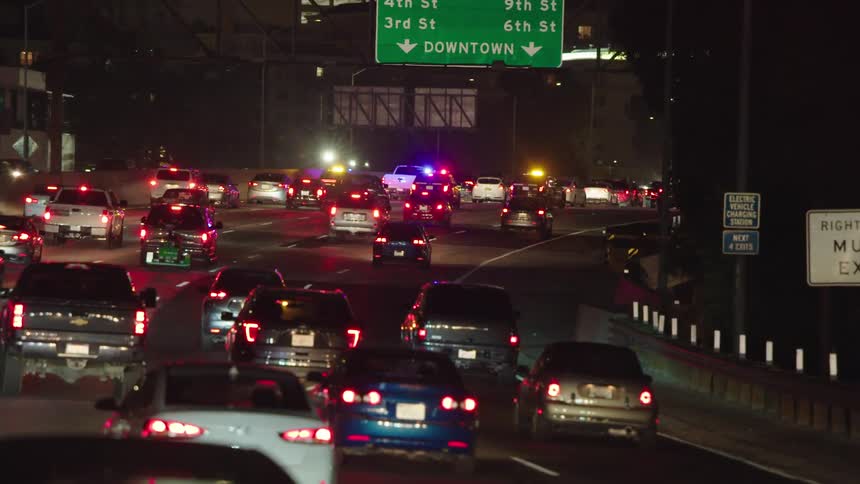 A highway with vehicles with buildings in the background