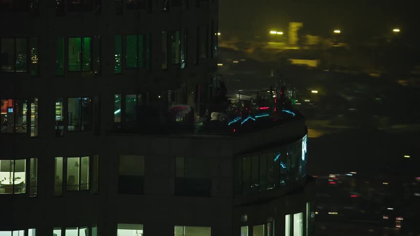 Bar on the pent house of a highrise in the city at night