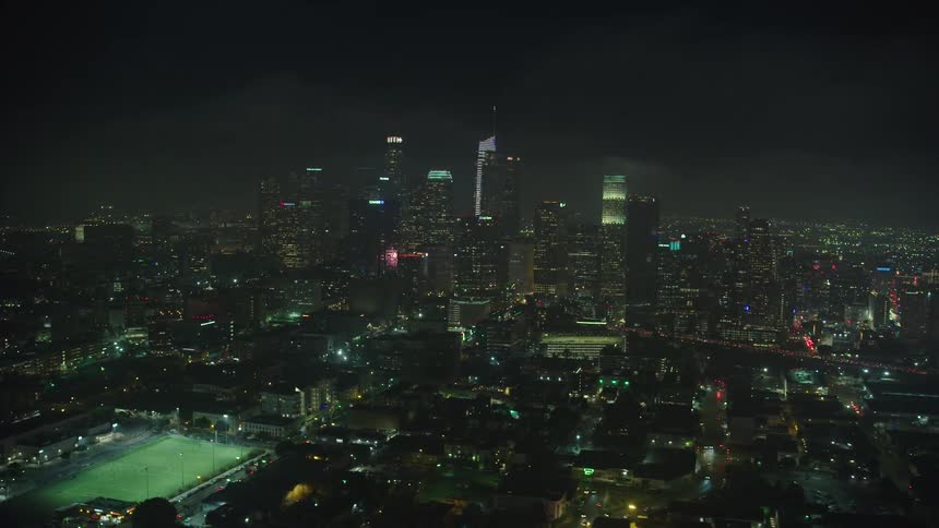 Aerial view of the illuminated city with tall buildings and skyscrapers at night