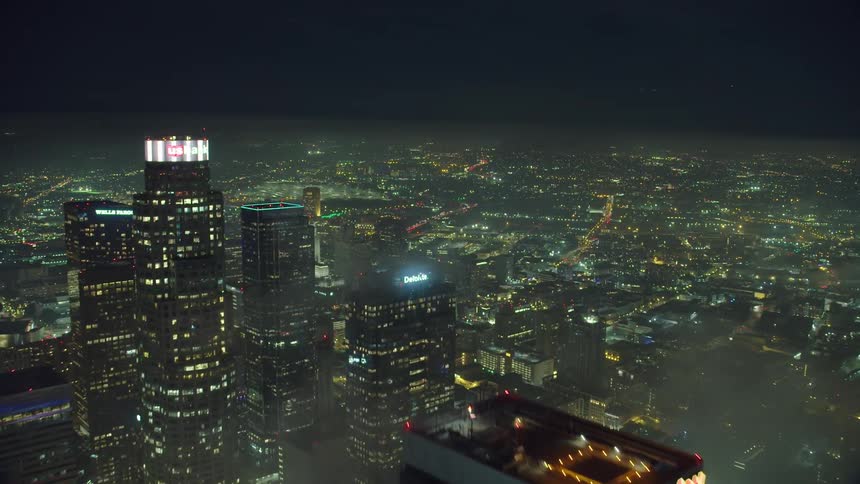 Aerial view of the illuminated city with tall buildings and skyscrapers at night