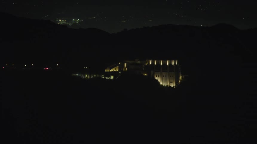 Aerial view of an illuminated mansion in mountains at night