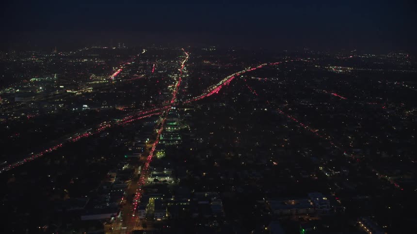 Traffic turns highways into lines crossing in the midst of a city at night