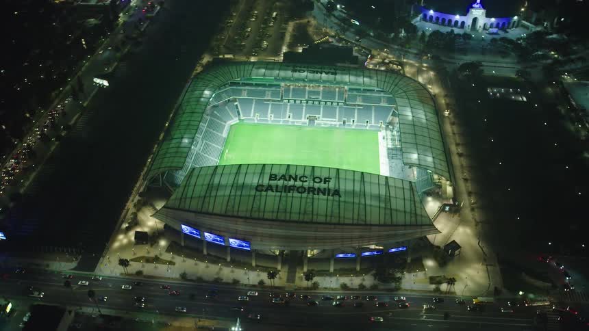 A floodlit soccer stadium viewed from above at night