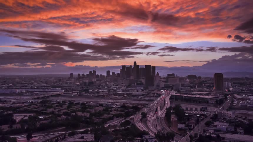 The sun starts to rise over a city skyline