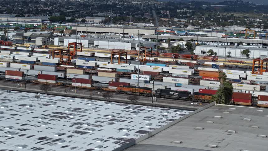 Cargo train passing through station in city at day