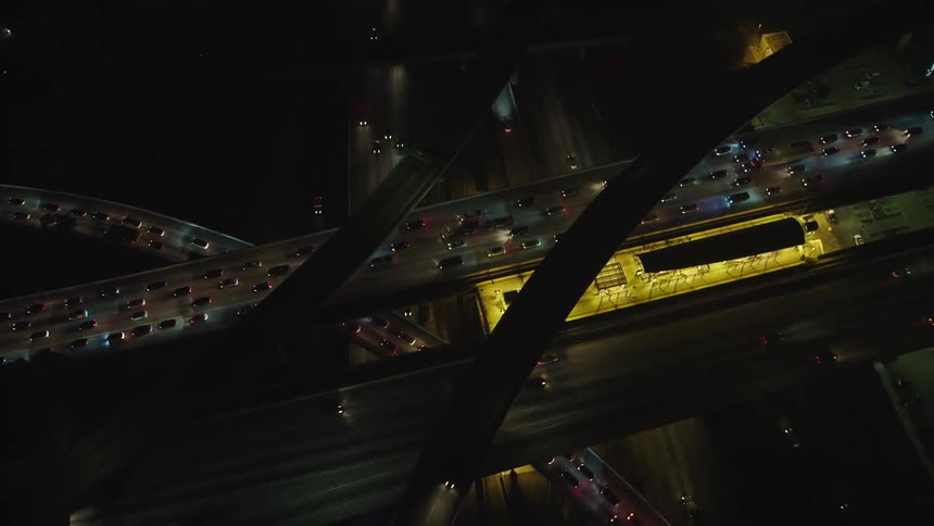 Cars drive down the interstate at night in a city