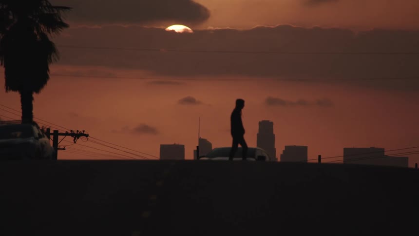 A man crosses the street in front of a car